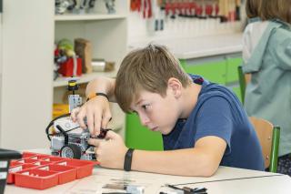 Ein Junge baut konzentriert an einem tierischen LEGO-Roboter