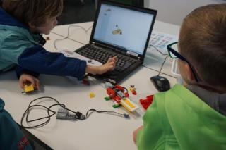 zwei Kinder programmieren ein Tiermodell aus Lego