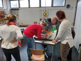 Eine Gruppe von Kolleginnen und Kollegen beim Teambuilding im Techniklabor