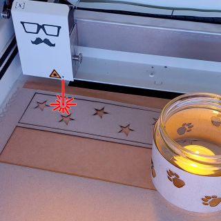 ein frisch gebautes Windlicht im Lasercutter, der die Banderole geschnitten hat